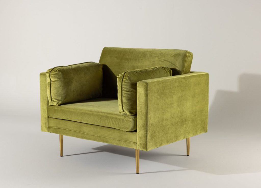 Fauteuil Boom en velours vert mis en scène dans un salon
