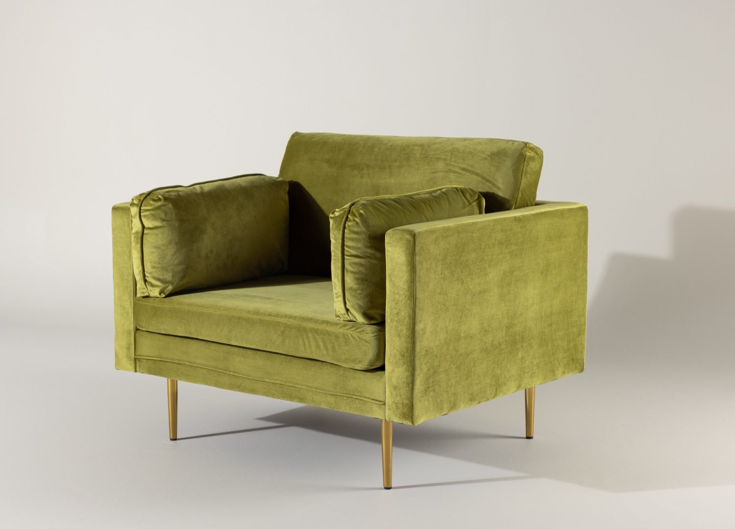 Fauteuil Boom en velours vert mis en scène dans un salon