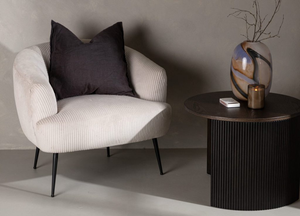 Fauteuil Derry en tissu beige mis en scène dans un salon