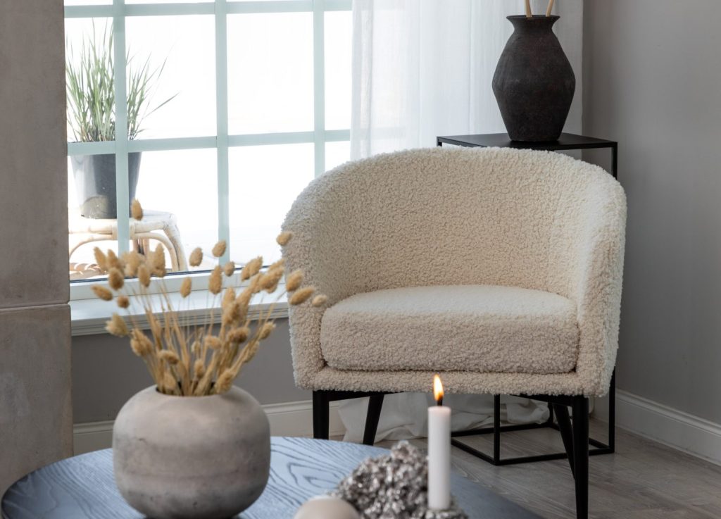 Fauteuil Fluffy en tissu teddy blanc mis en scène dans un salon