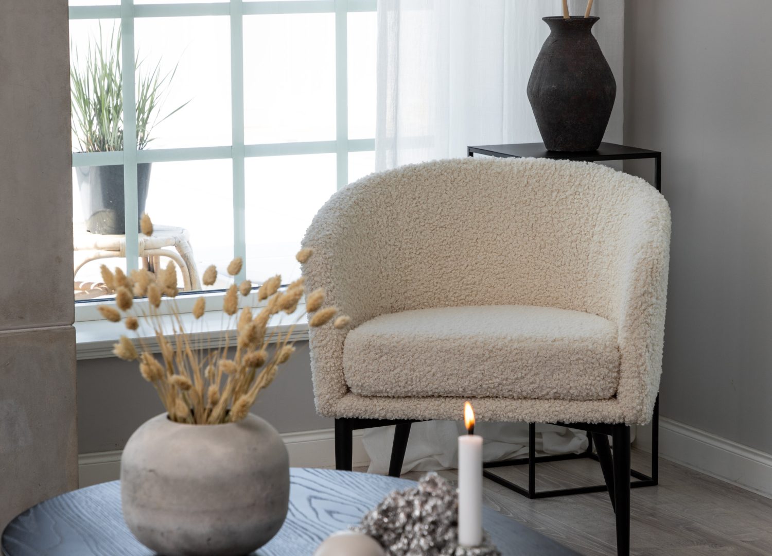 Fauteuil Fluffy en tissu teddy blanc mis en scène dans un salon