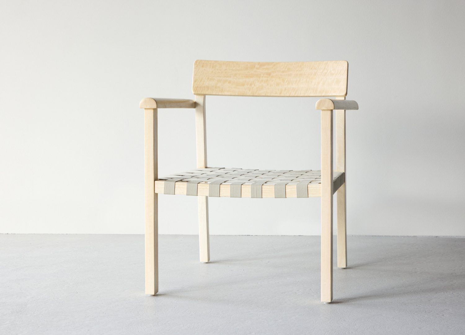 Fauteuil Krois en tissu gris mis en scène dans un salon