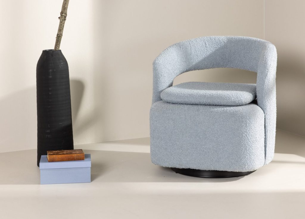 Fauteuil Laurel en tissu bouclé bleu clair mis en scène dans un salon