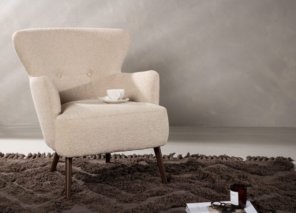 Fauteuil Lincoln en tissu bouclé beige mis en scène dans un salon