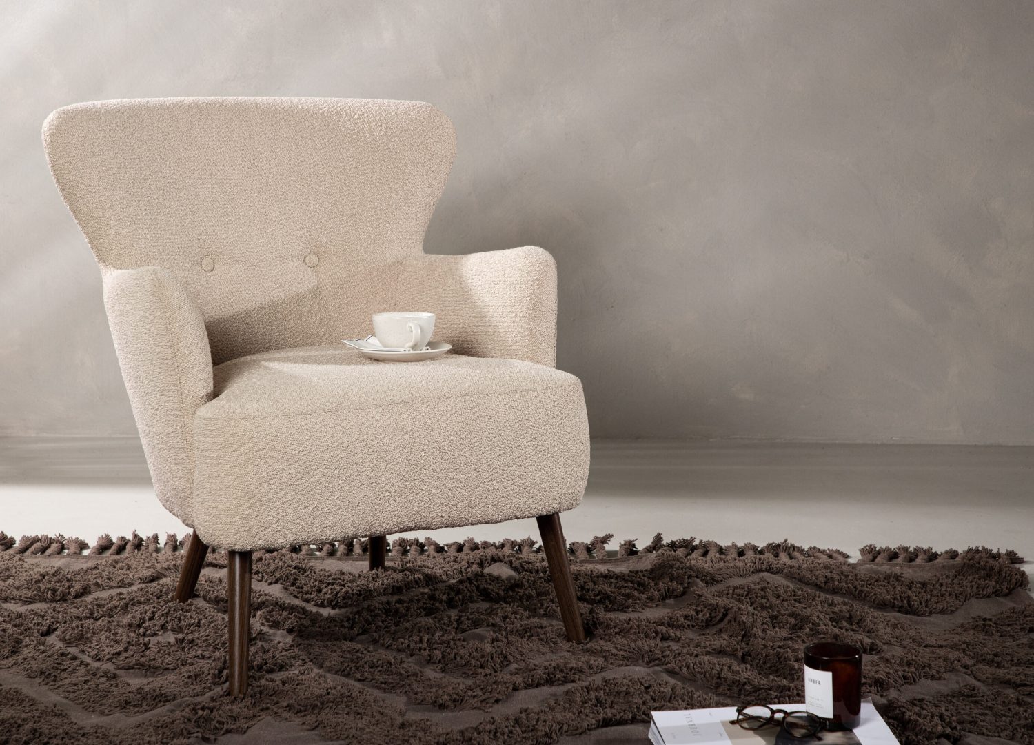 Fauteuil Lincoln en tissu bouclé beige mis en scène dans un salon