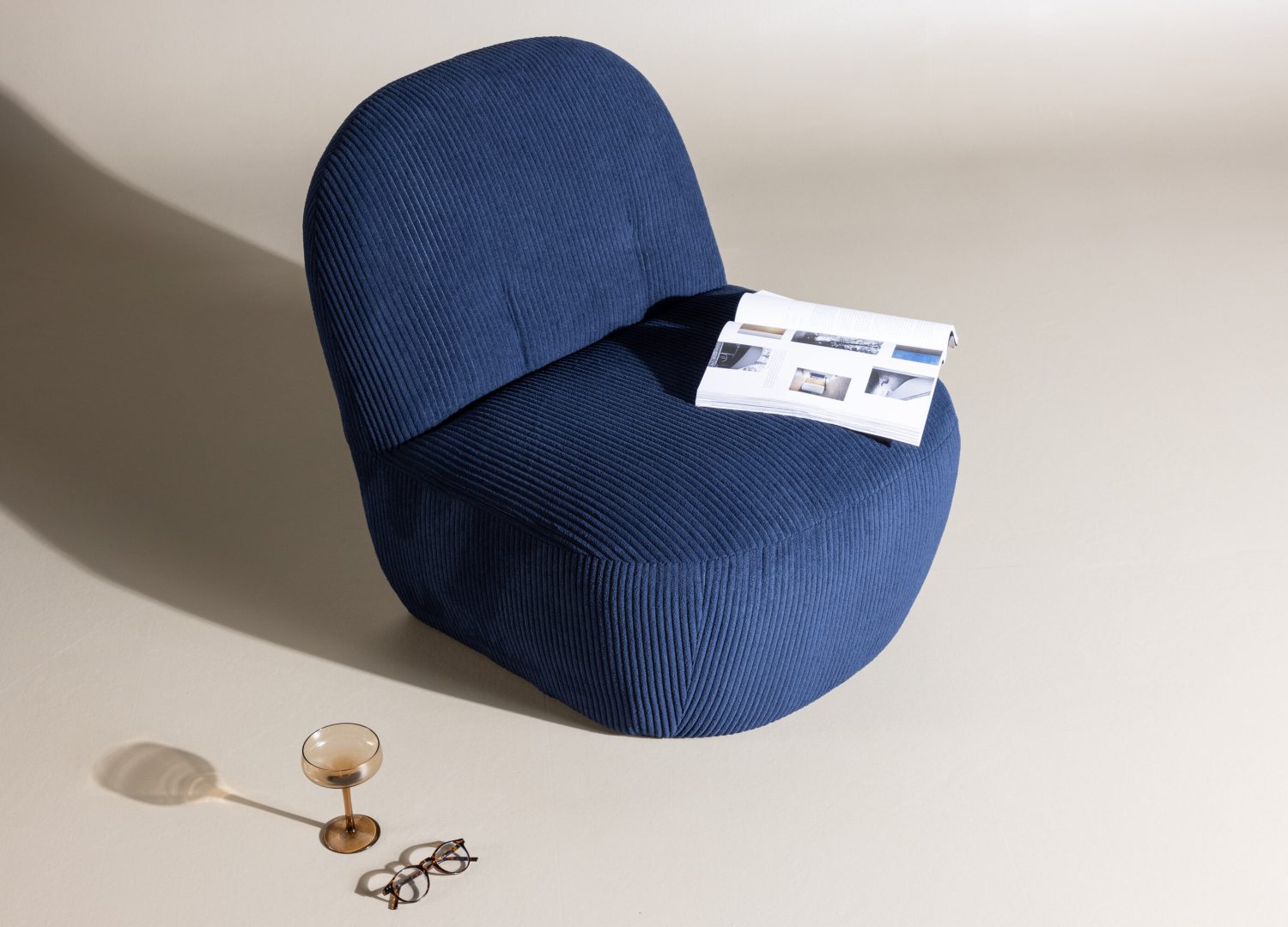 Fauteuil Mahla en tissu bleu marine mis en scène dans un salon