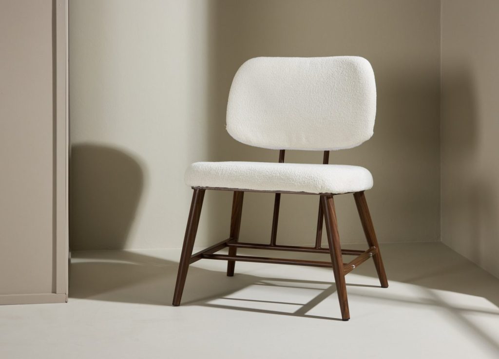 Fauteuil Midland en tissu bouclé blanc mis en scène dans un salon