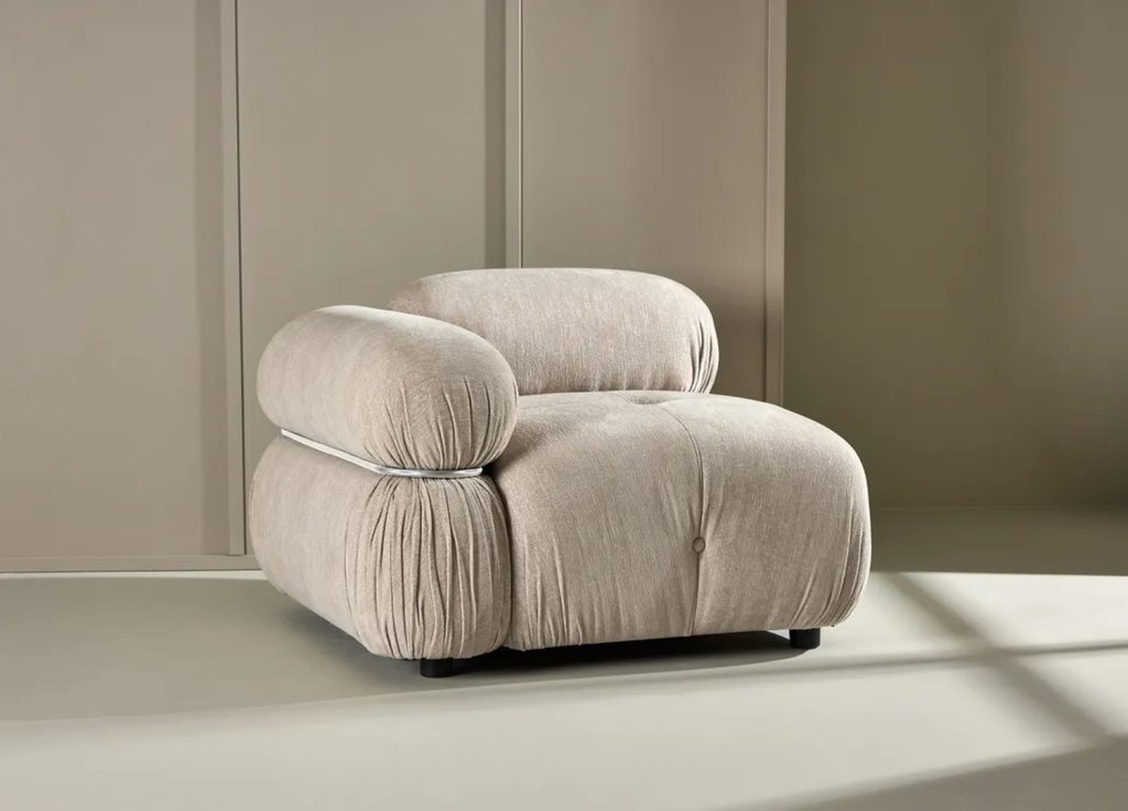 Fauteuil Mika beige en tissu avec accoudoir arrondi, vue de côté