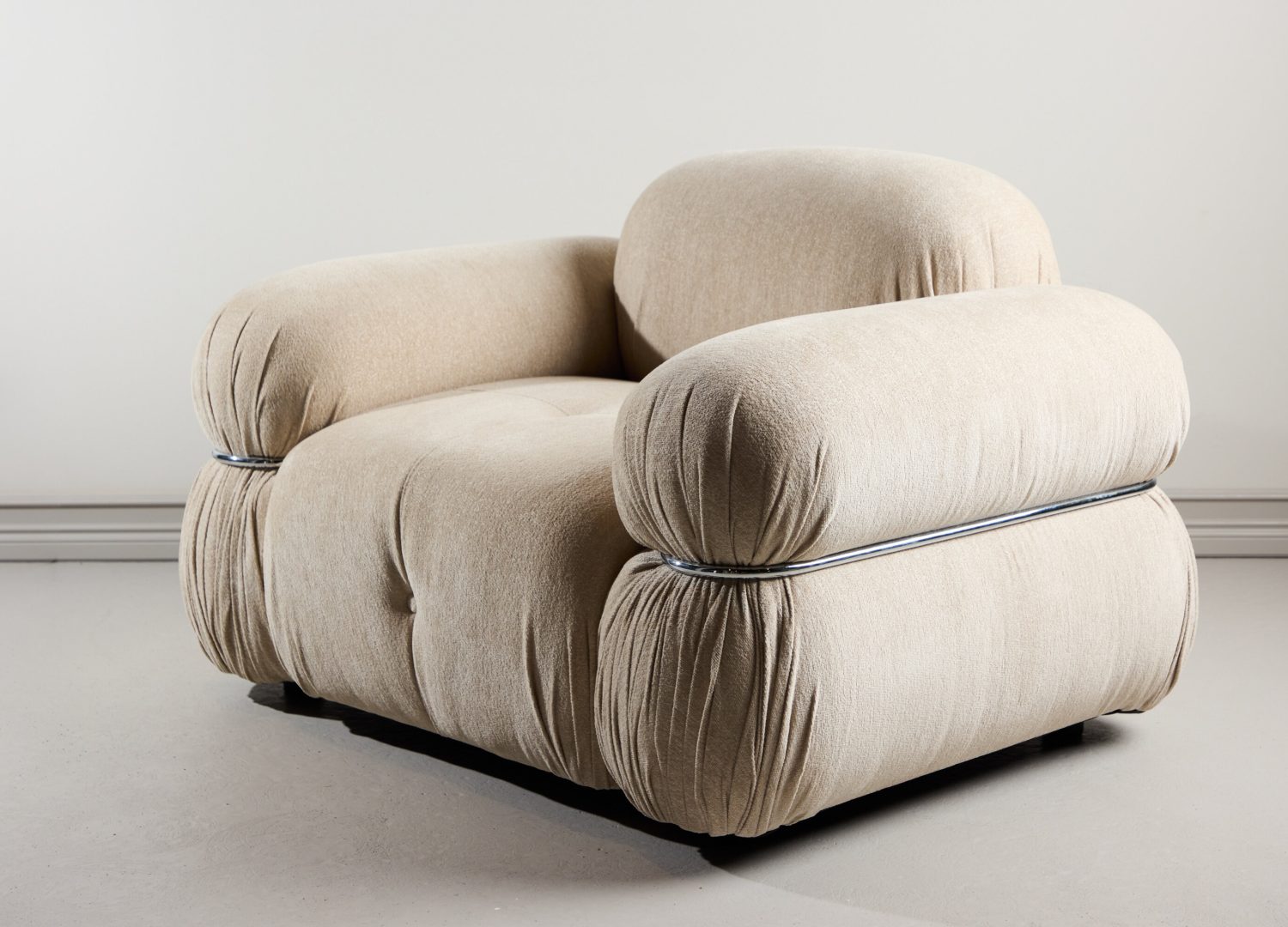 Fauteuil Mika en tissu beige mis en scène dans un salon