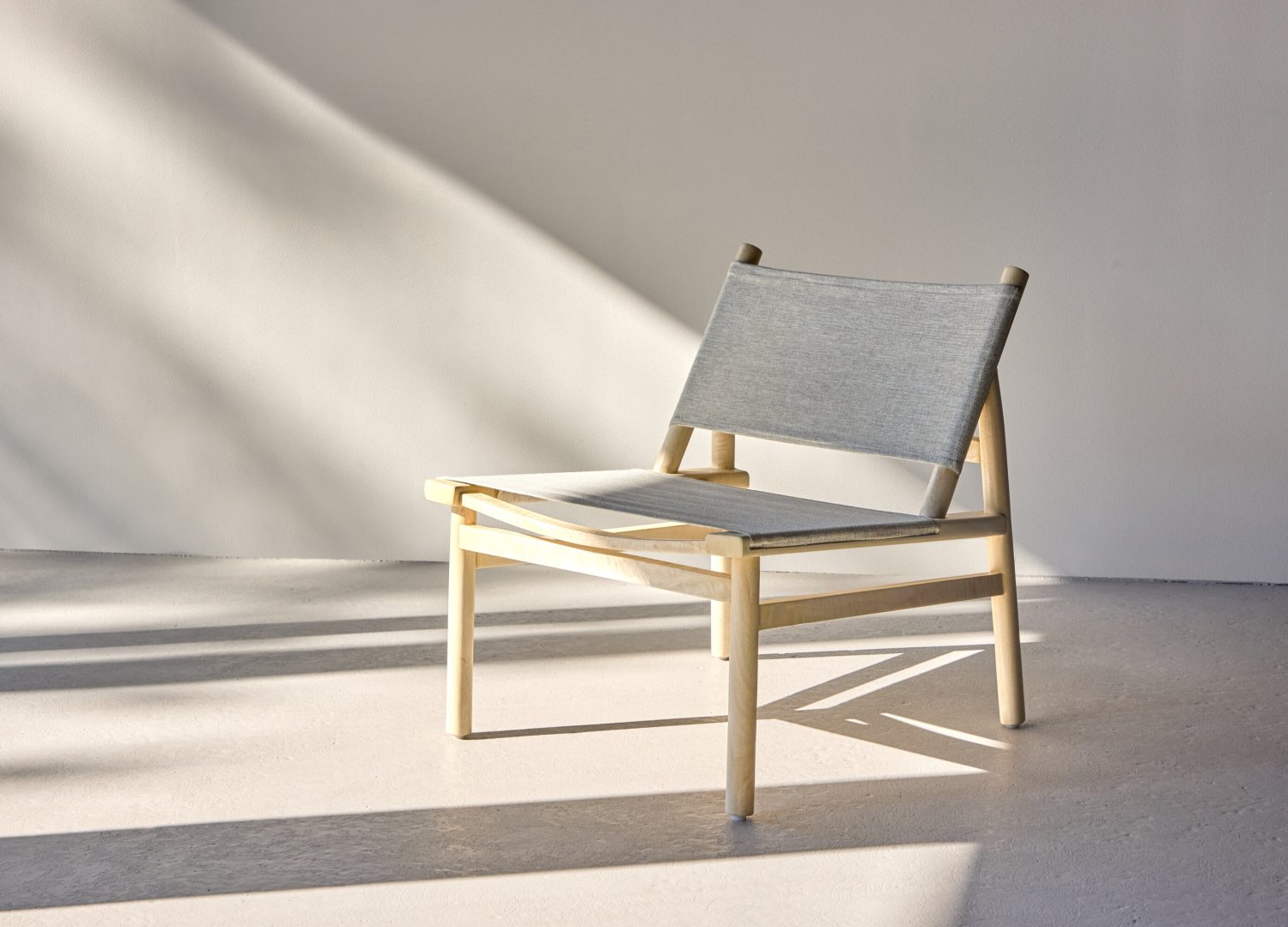 Fauteuil Millo en tissu gris mis en scène dans un salon