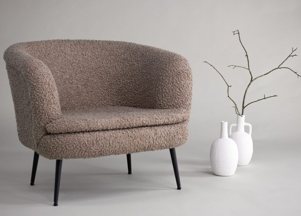 Fauteuil Nordkoster en tissu beige mis en scène dans un salon