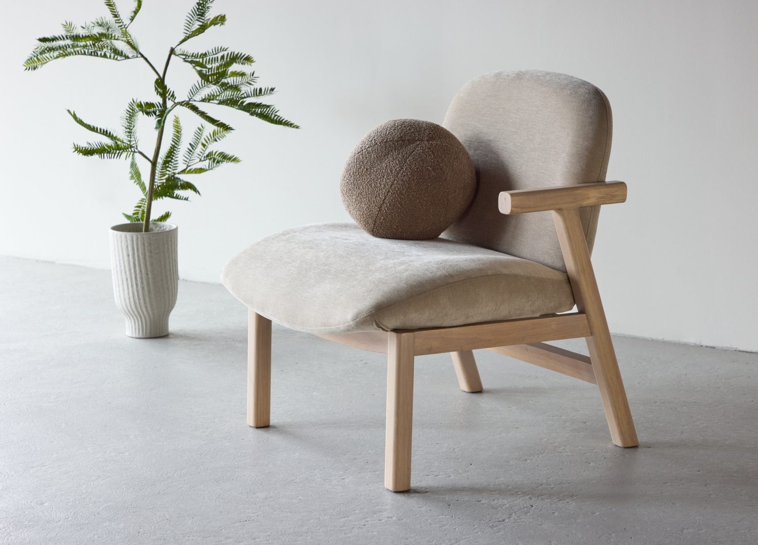 Fauteuil Rile en tissu beige mis en scène dans un salon