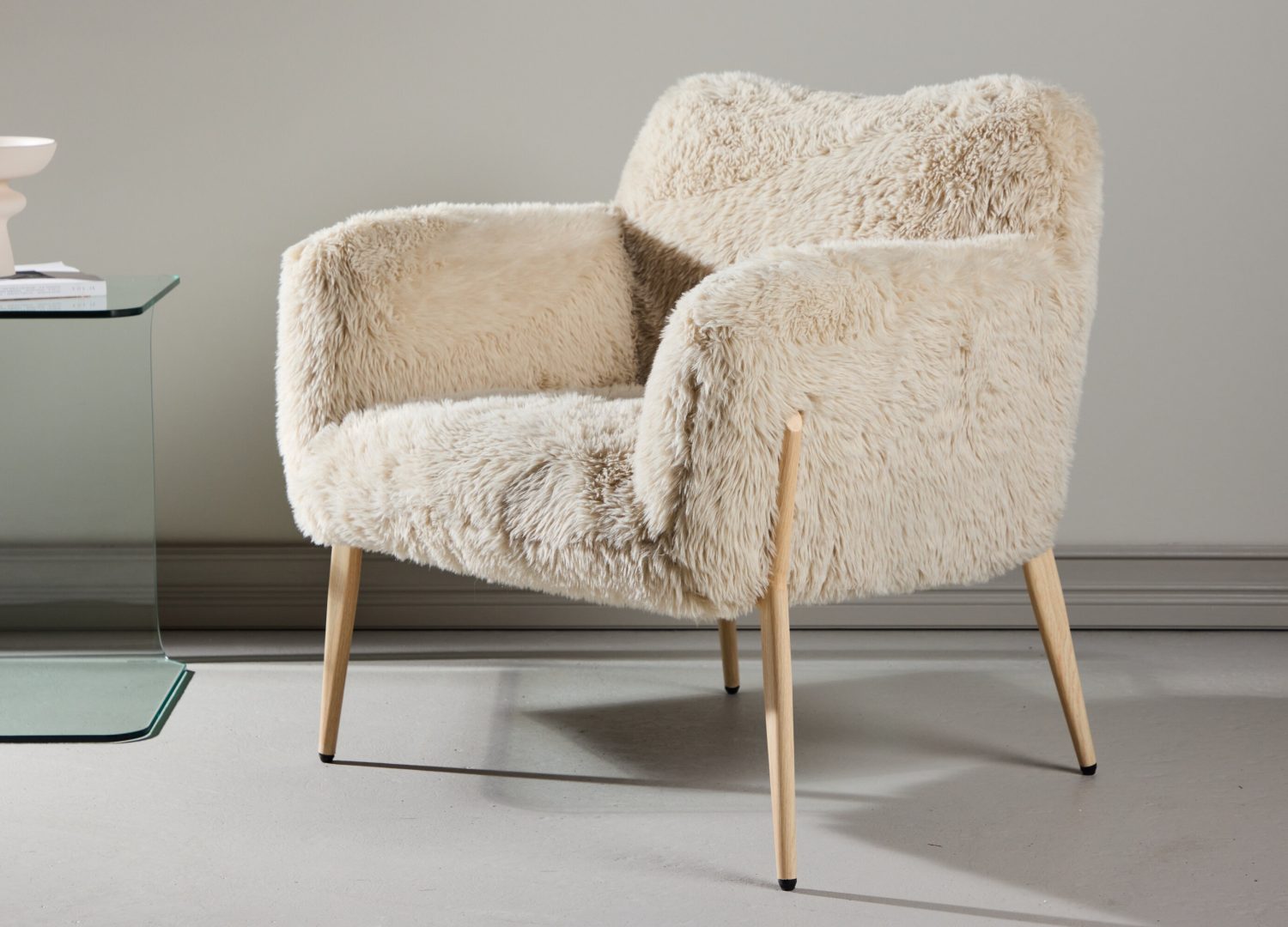 Fauteuil Zenzi en tissu beige mis en scène dans un salon
