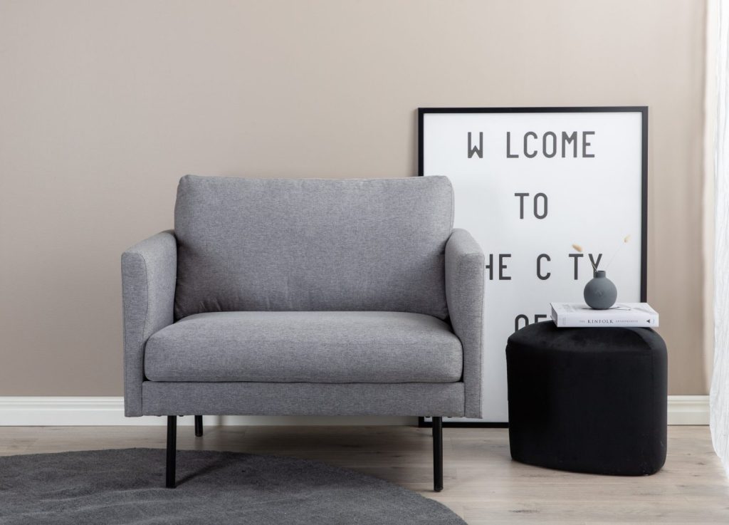 Fauteuil Zoom en tissu gris mis en scène dans un salon