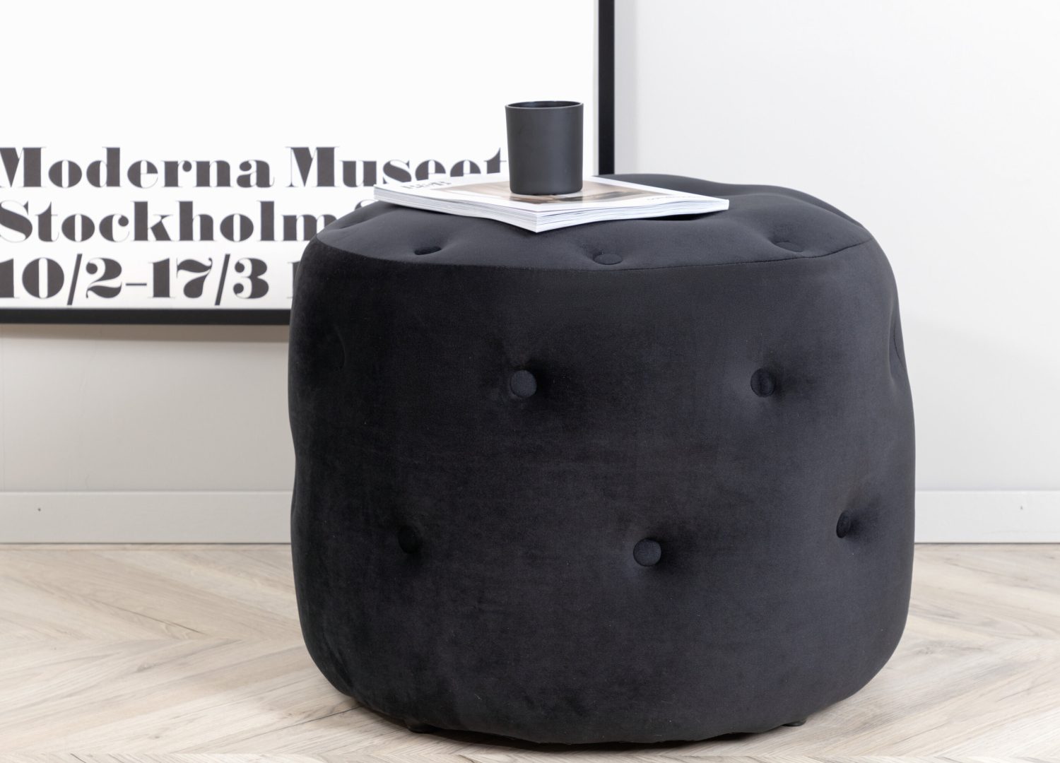 Pouf Benjamin velours en polyester noir Ø 55 cm mis en scène dans un intérieur