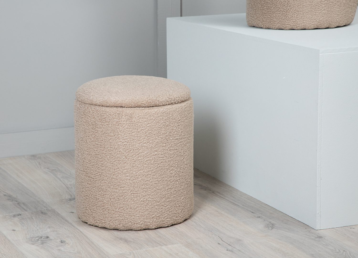 Pouf Limpen tissu bouclette en polyester beige Ø 32 cm présenté dans une ambiance décorative