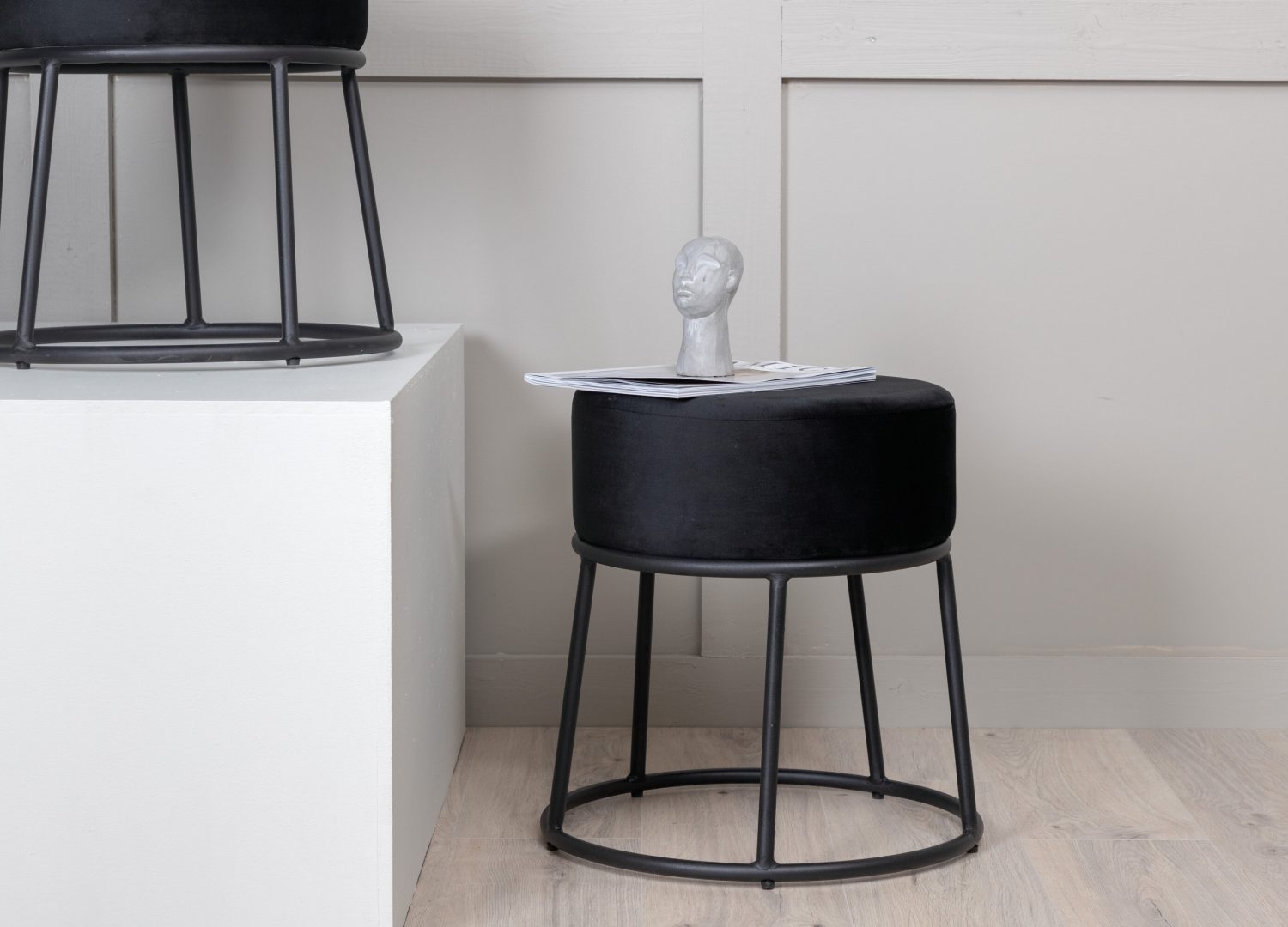 Pouf Petra tissu bouclette en polyester noir Ø 46 cm mis en scène dans un intérieur