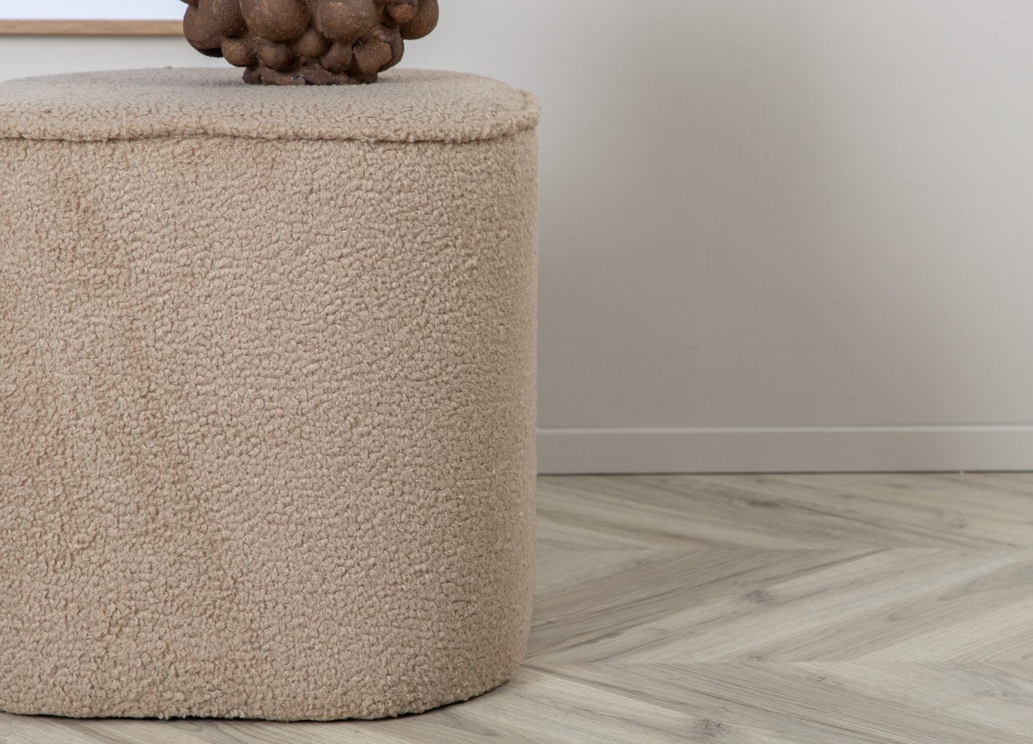 Pouf Piff tissu bouclette en polyester beige Ø 44 cm présenté dans une ambiance décorative
