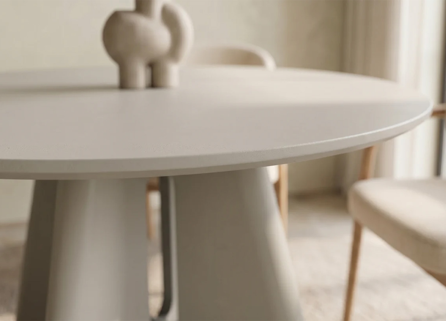 Détail du plateau biseauté gris ciment de la table ronde Ovélis