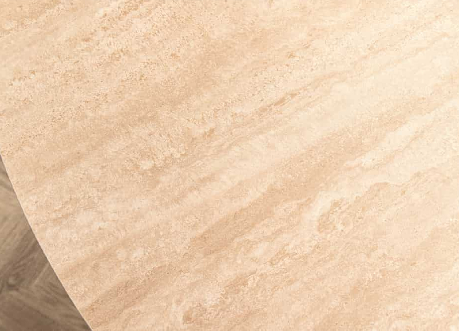 Plateau rond en céramique effet travertin beige de la table Ovélis vu de dessus