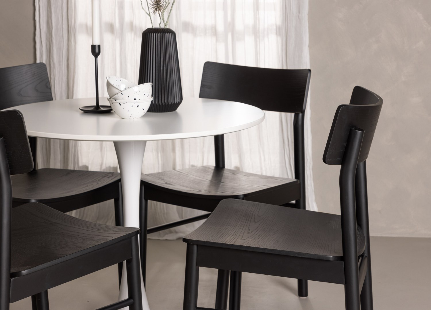 Table ronde Hamden et 4 chaises Montros présentées dans un intérieur contemporain