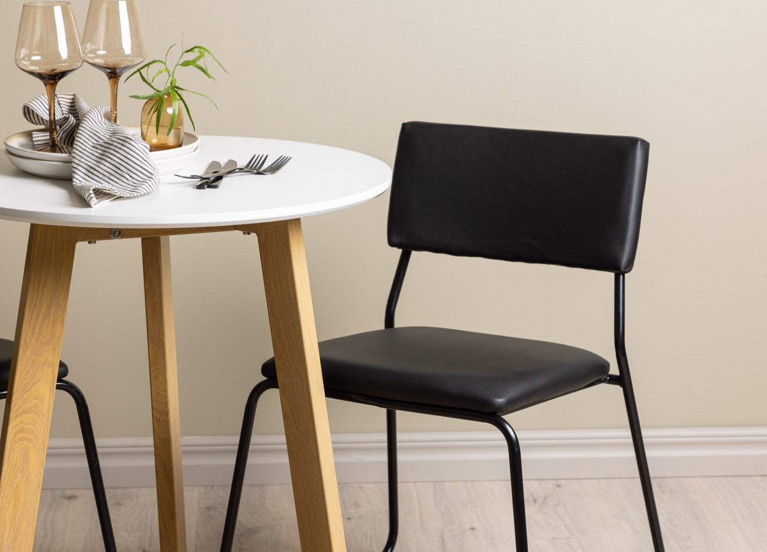 Table ronde Leonora et 2 chaises Kenth présentées dans un intérieur contemporain