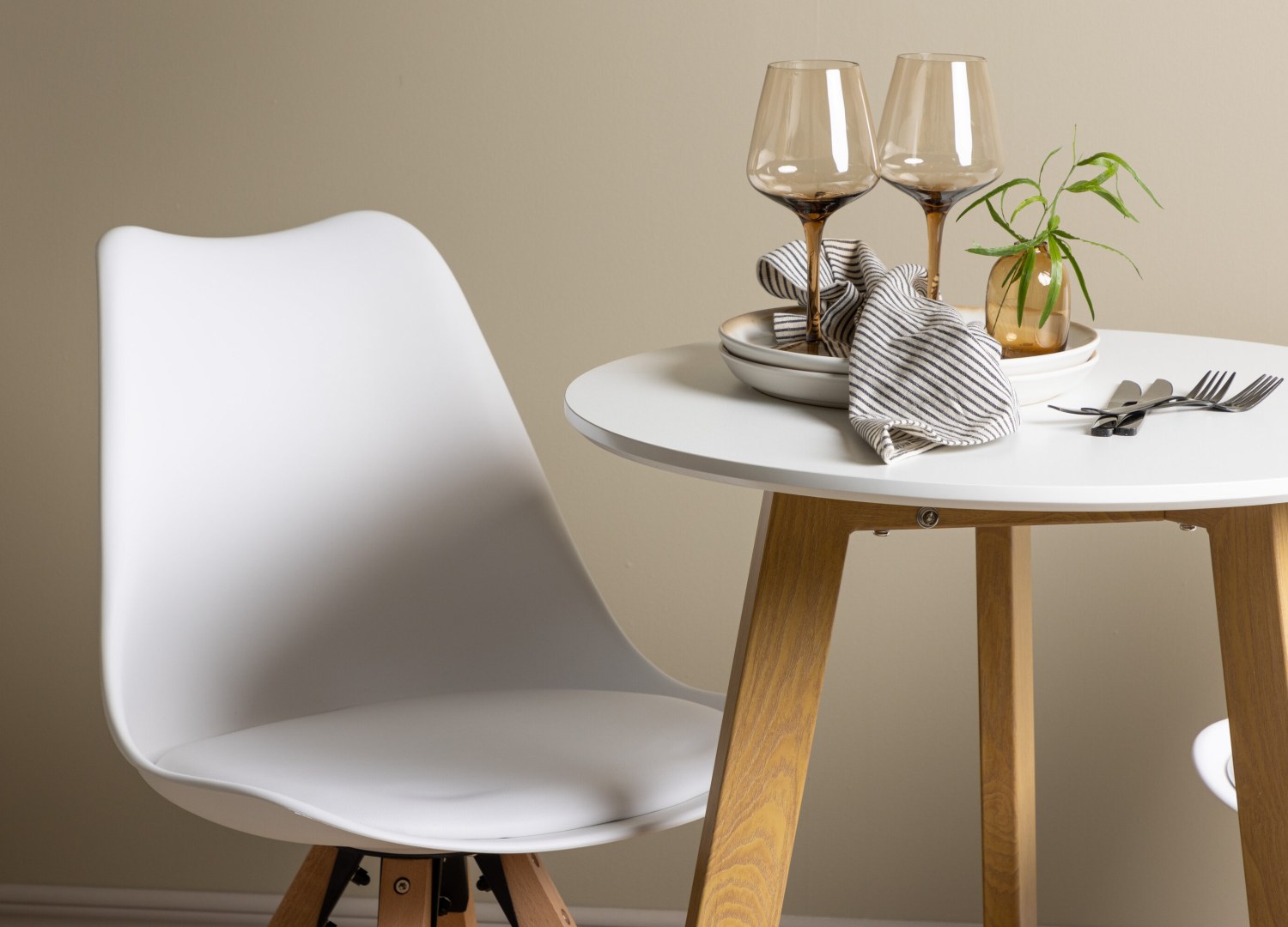 Table ronde Leonora et 2 chaises Zeno présentées dans un intérieur contemporain