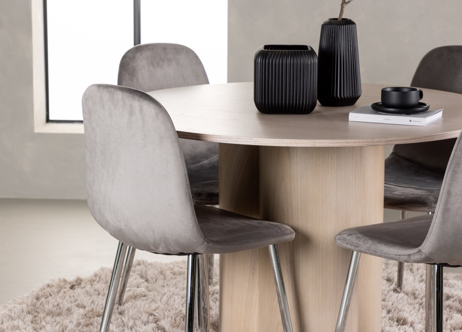 Table ronde Olivia et 4 chaises Eva présentées dans un intérieur contemporain