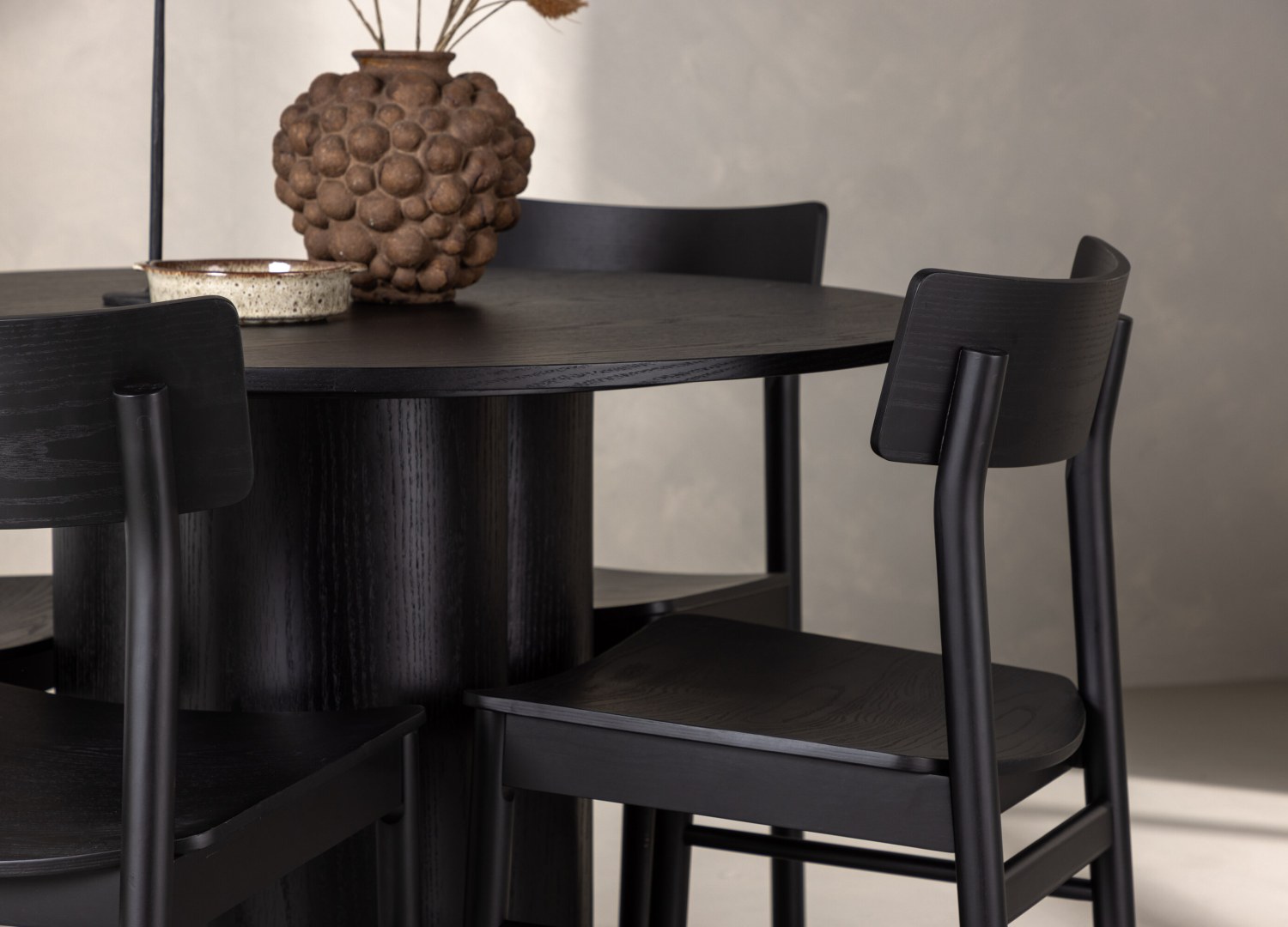 Table ronde Olivia et 4 chaises Montros présentées dans un intérieur contemporain