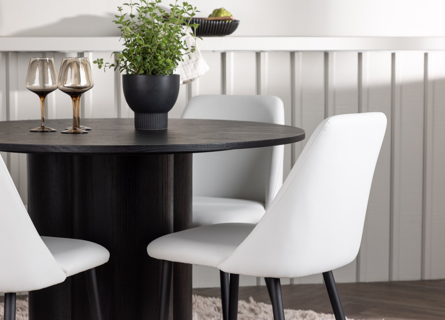 Table ronde Olivia et 4 chaises Night présentées dans un intérieur contemporain