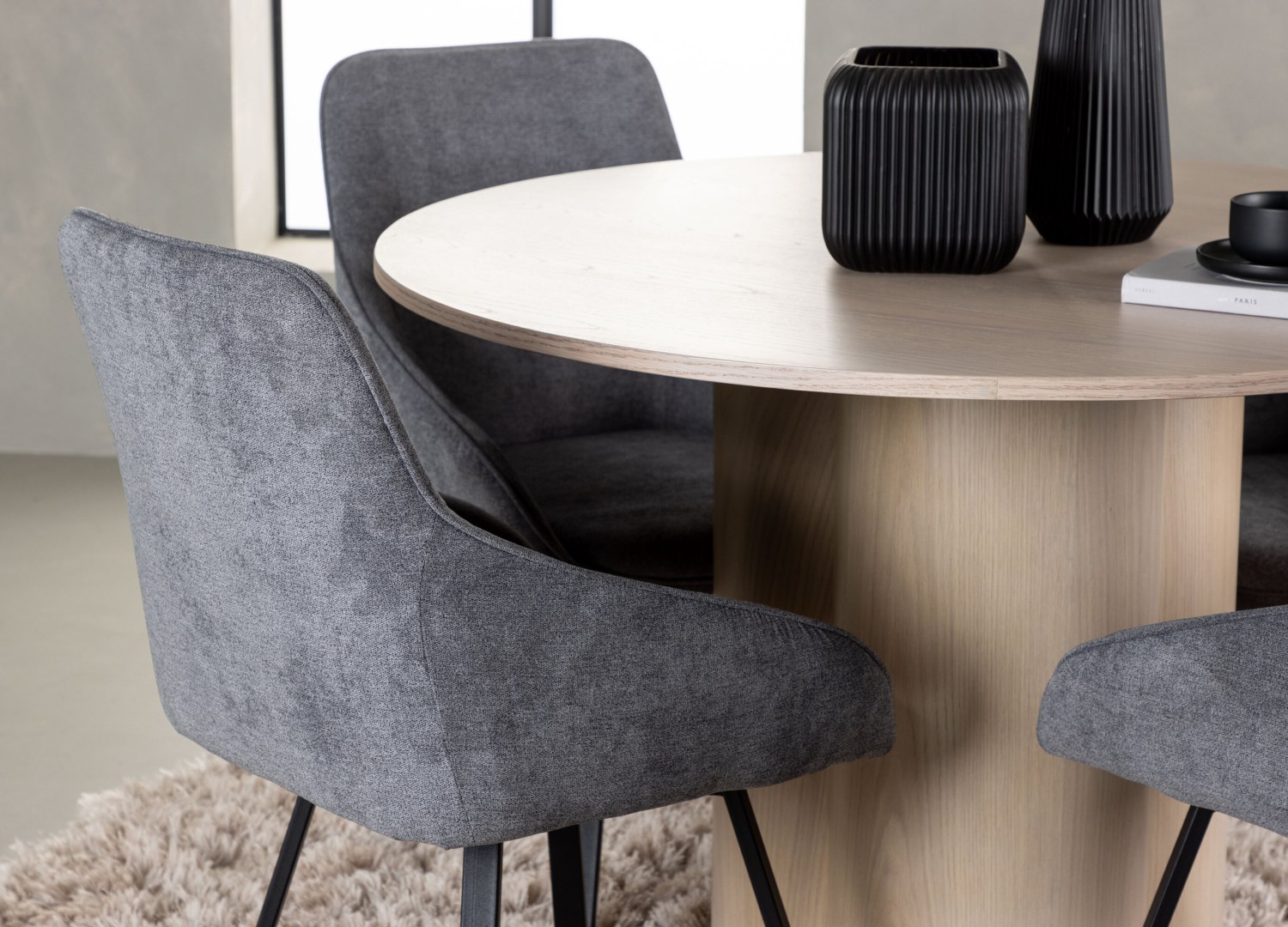 Table ronde Olivia et 4 chaises Rosie présentées dans un intérieur contemporain