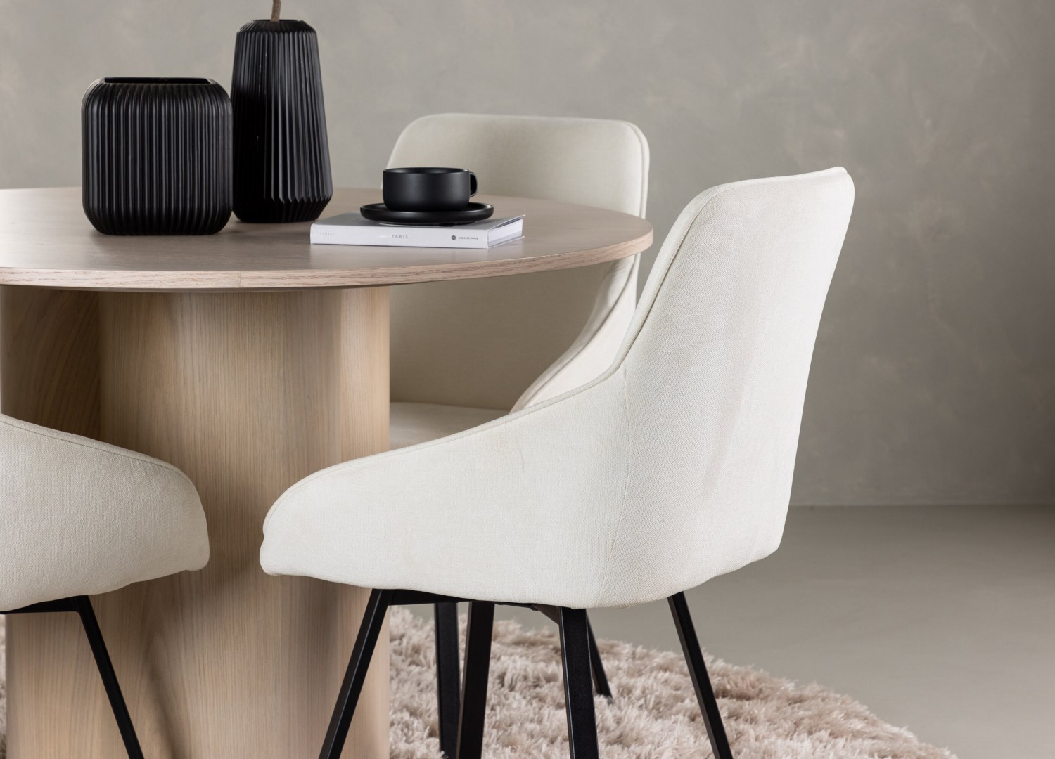 Table ronde Olivia et 4 chaises Rosie présentées dans un intérieur contemporain