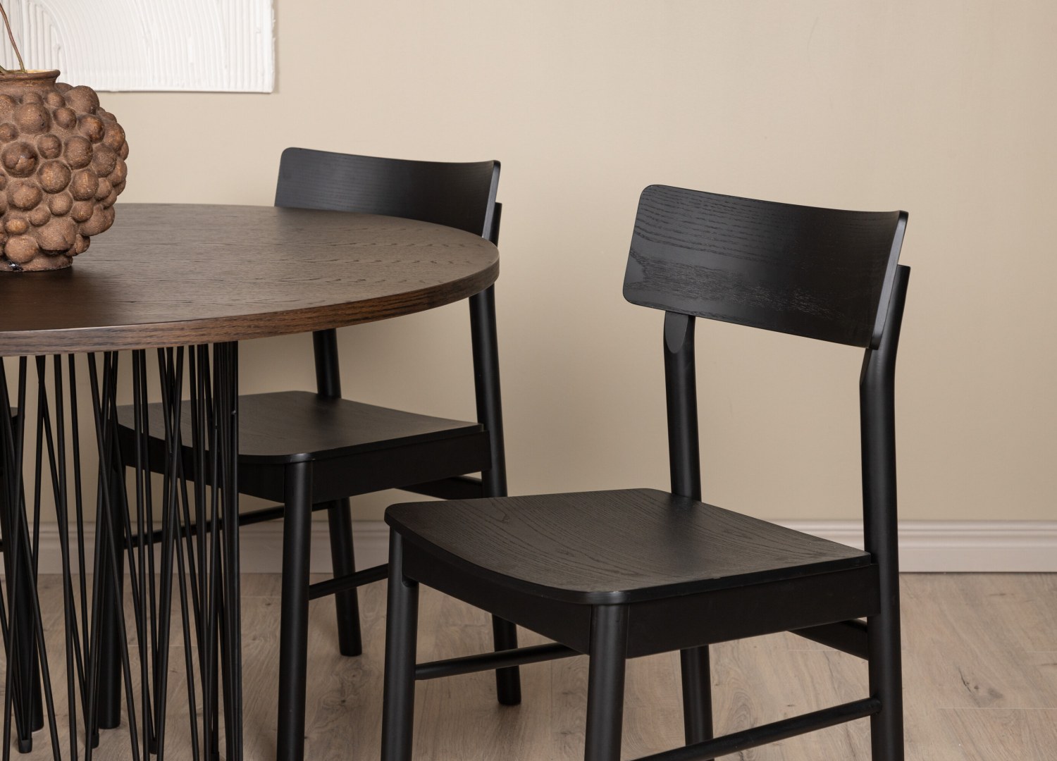 Table ronde Stone et 4 chaises Montros présentées dans un intérieur contemporain