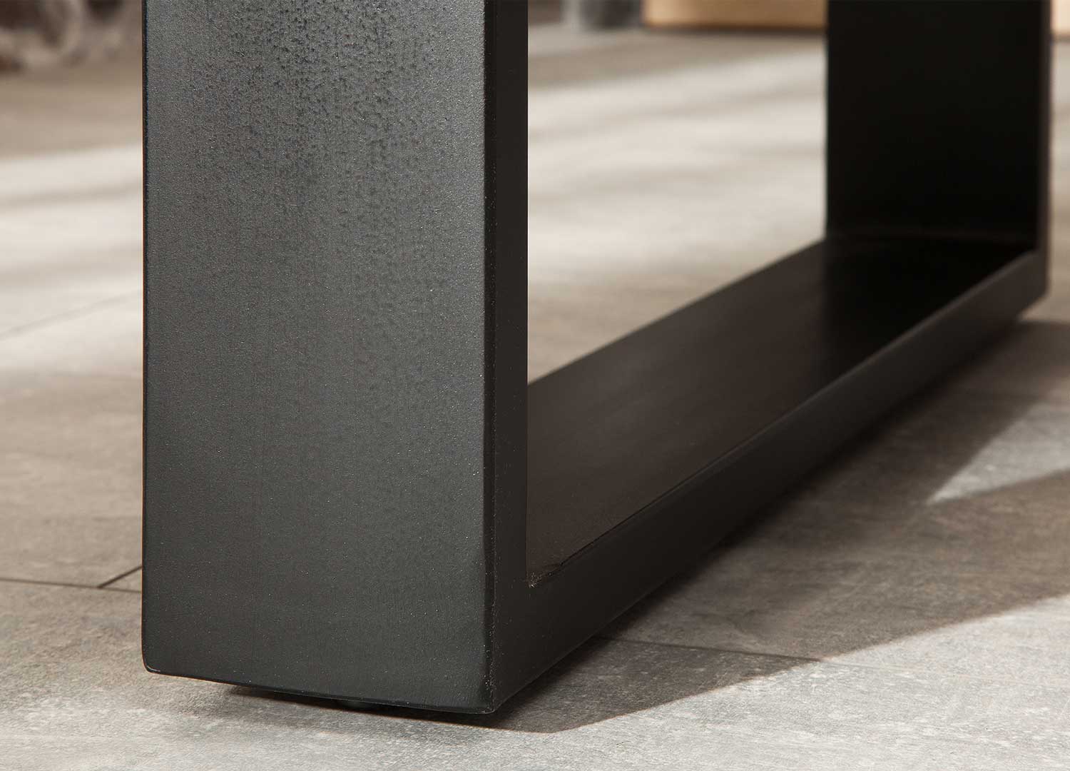 Détail du pied en métal noir de la table à manger en manguier massif