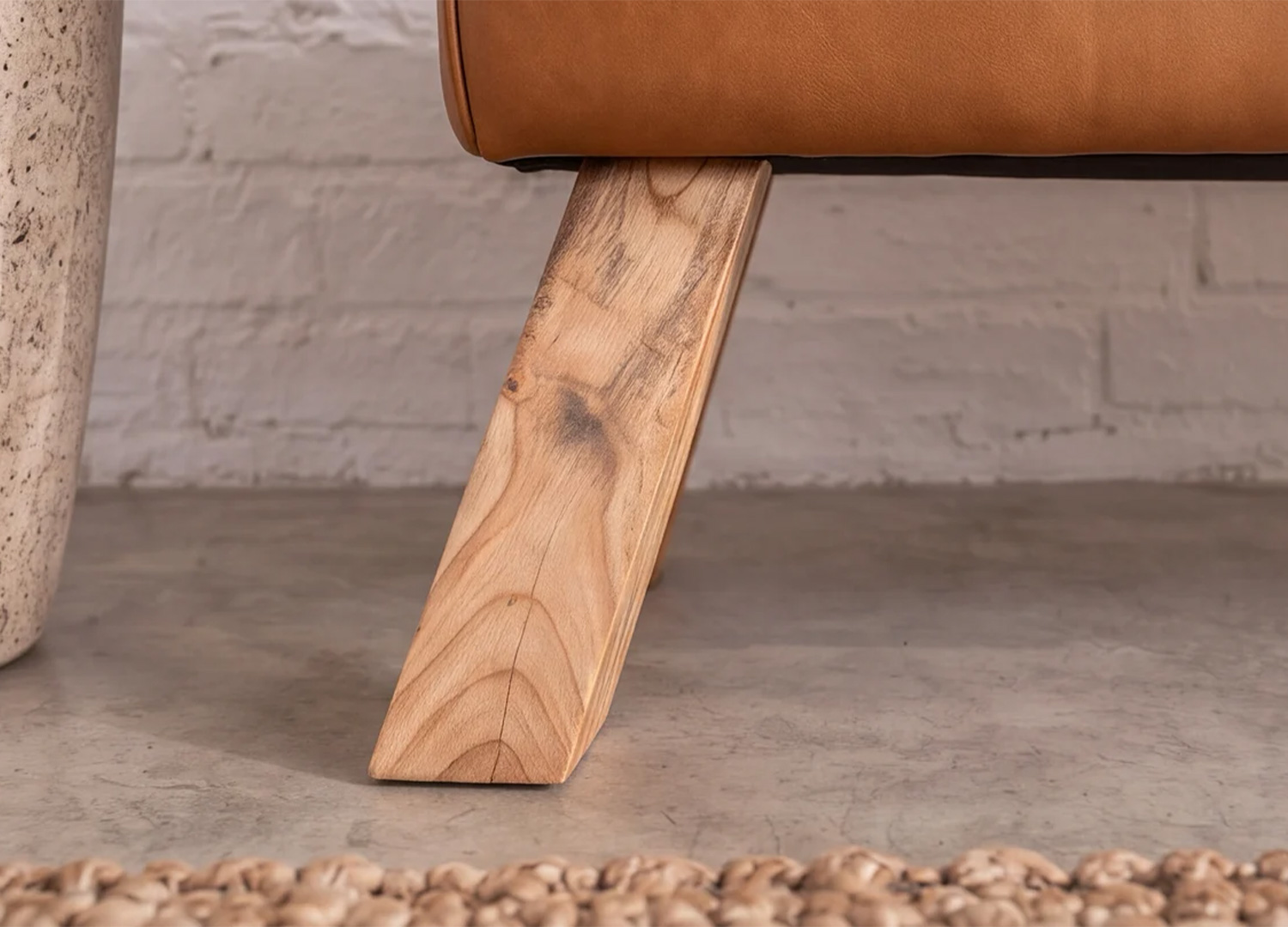 Détail du pied incliné en bois du banc CALVEO avec veinures apparentes