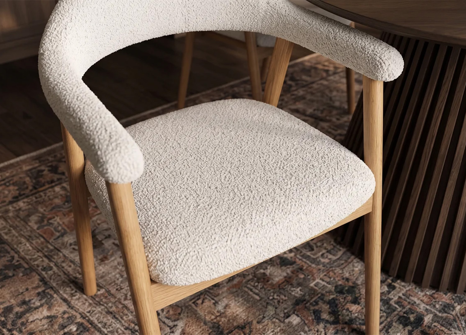 Vue en plongée sur l'assise rembourrée et les accoudoirs enveloppants de la chaise ELVANO en tissu beige texturé