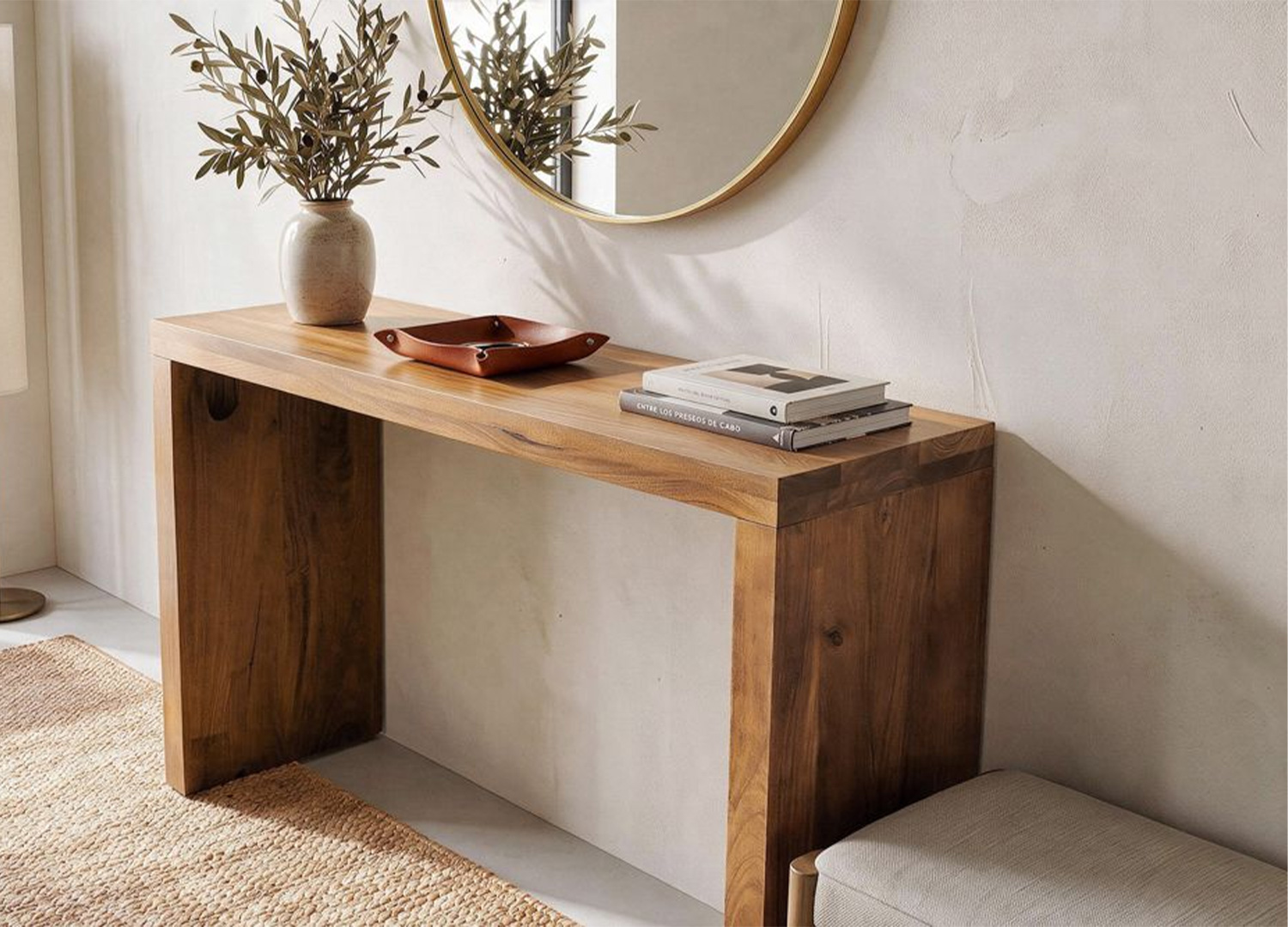 Console d'entrée en manguier massif aménagée sous un miroir rond avec vase et objets décoratifs