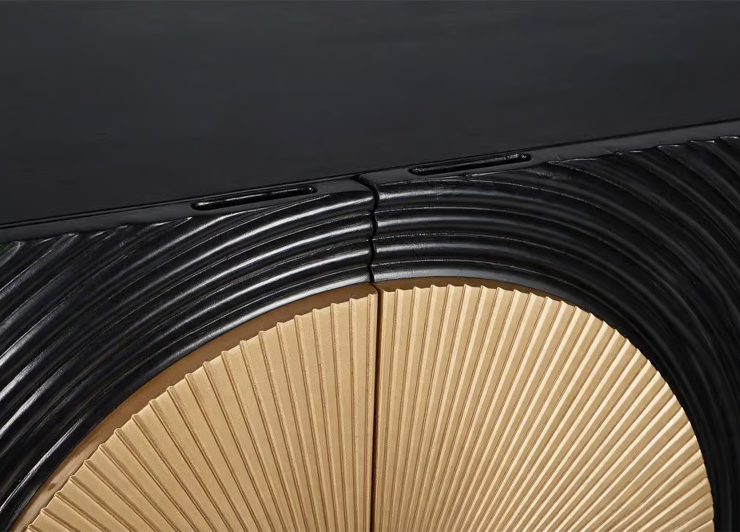 Détail des prises de main discrètes en partie haute des portes et du motif doré du buffet noir