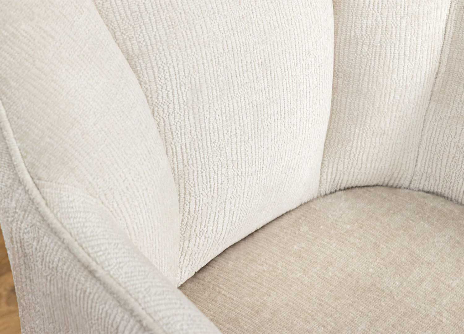 Détail du dossier rembourré en tissu chenille beige avec surpiqûres verticales