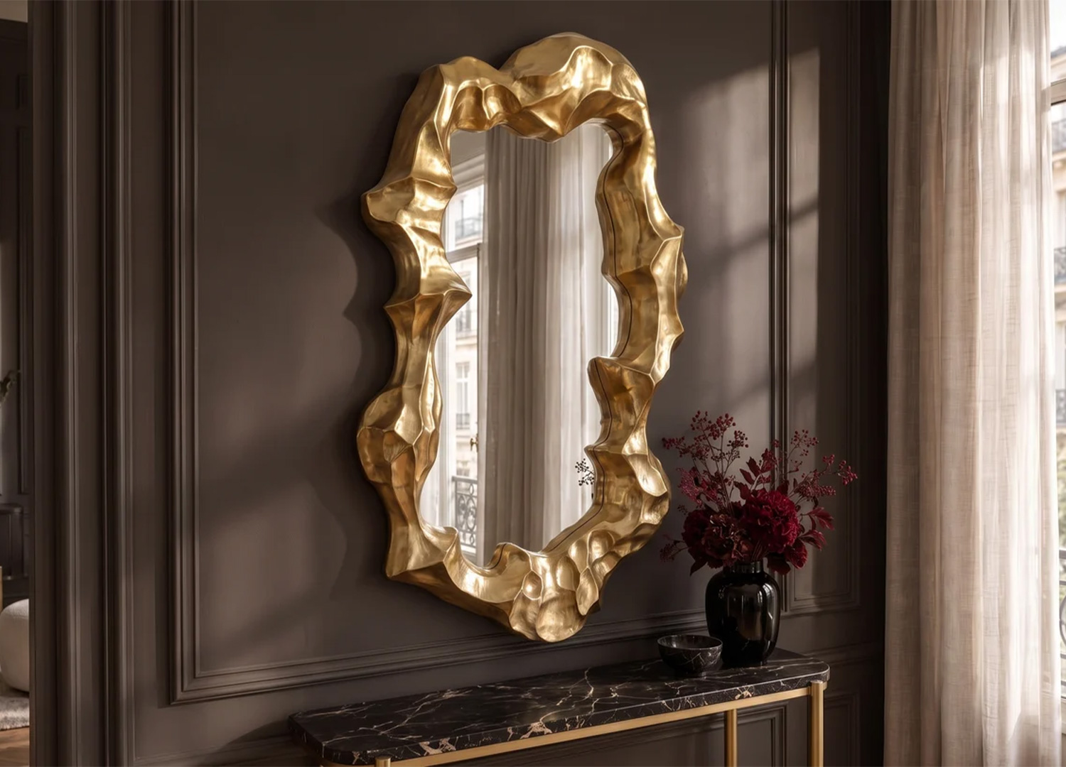 Grand miroir doré de forme organique accroché dans un salon élégant aux murs clairs