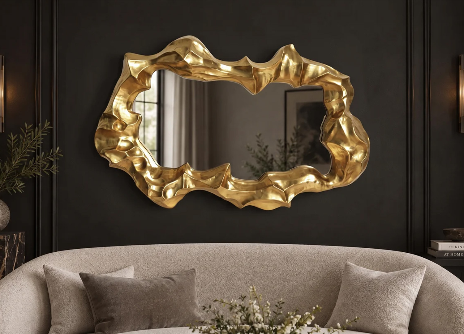 Miroir mural doré horizontal à forme organique installé au-dessus d’un canapé beige