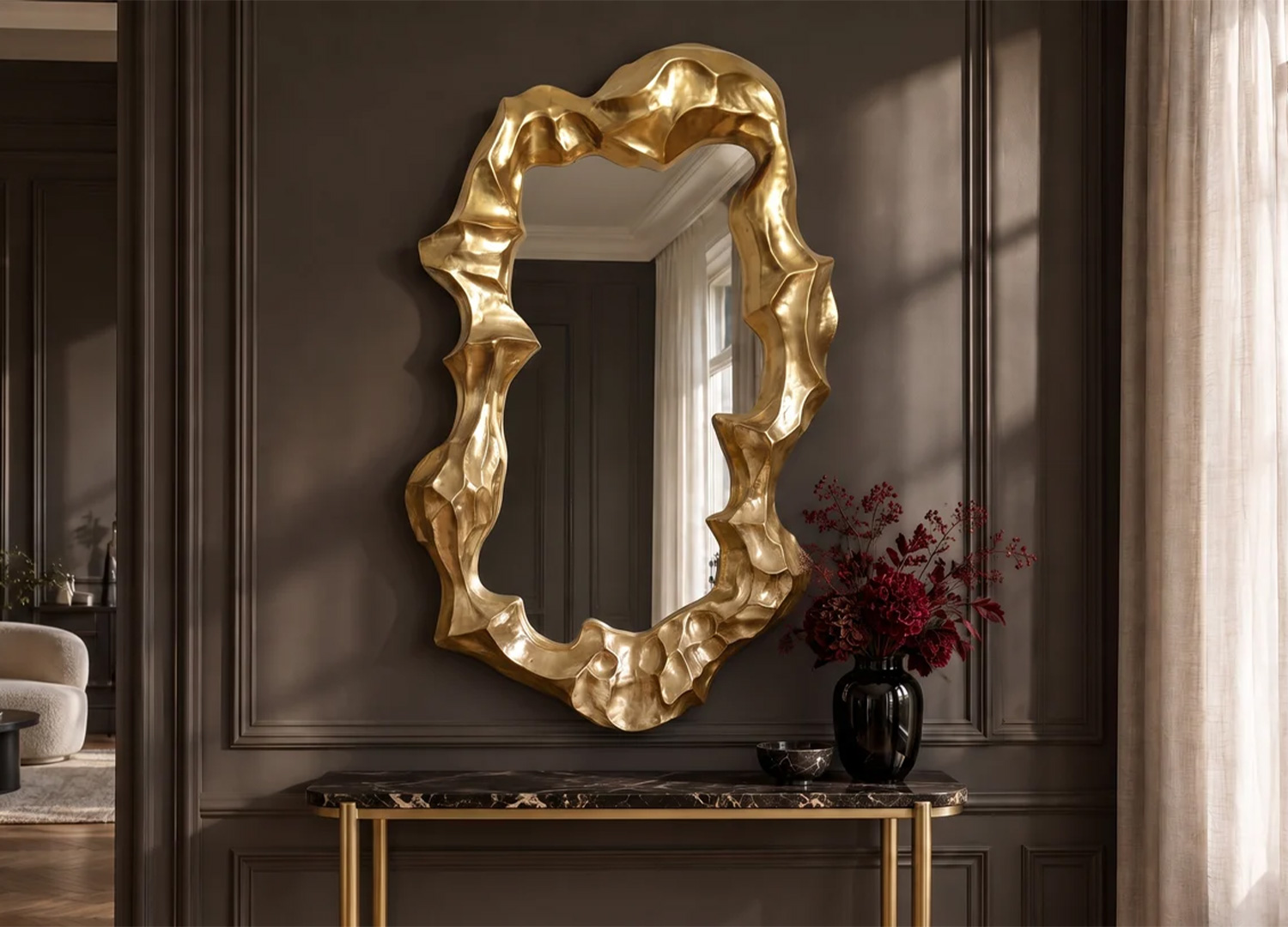Miroir mural vertical doré à cadre irrégulier présenté au-dessus d’une console en marbre noir