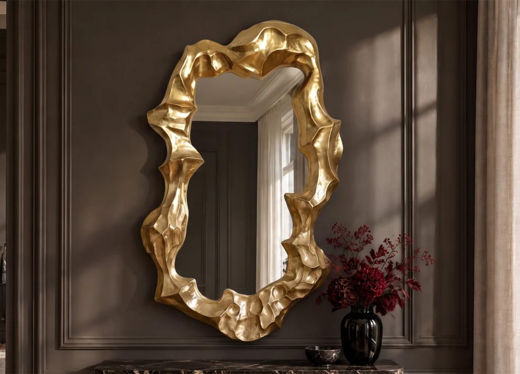 Grand miroir mural doré aux contours sculpturaux installé sur un mur sombre au-dessus d’une console